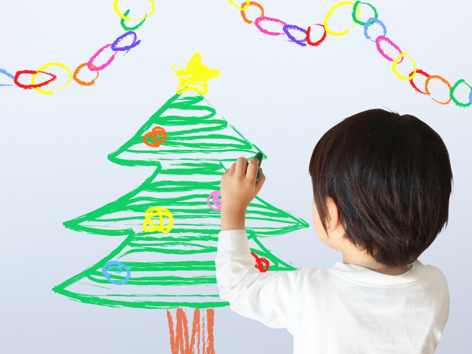 クリスマスツリーを描く子ども