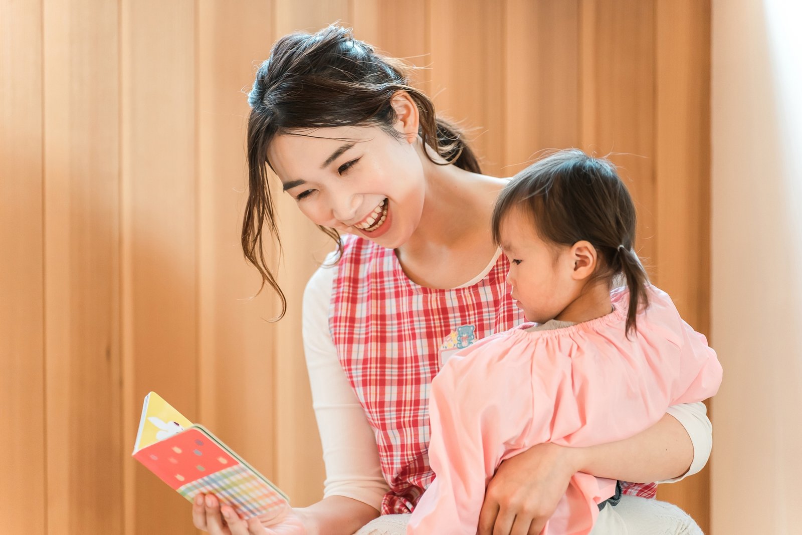 絵本を読む保育士と子ども
